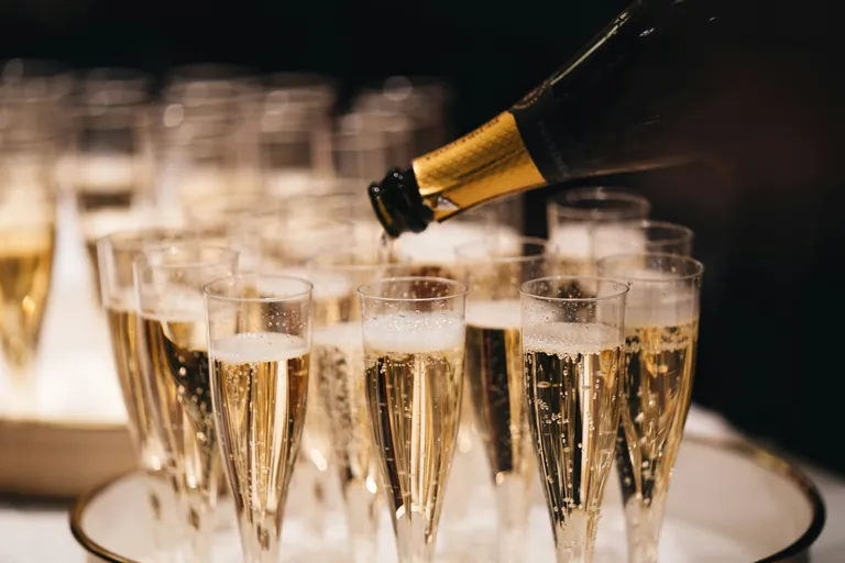 Cava sirviéndose en una bandeja de copas para el brindis de fin de año