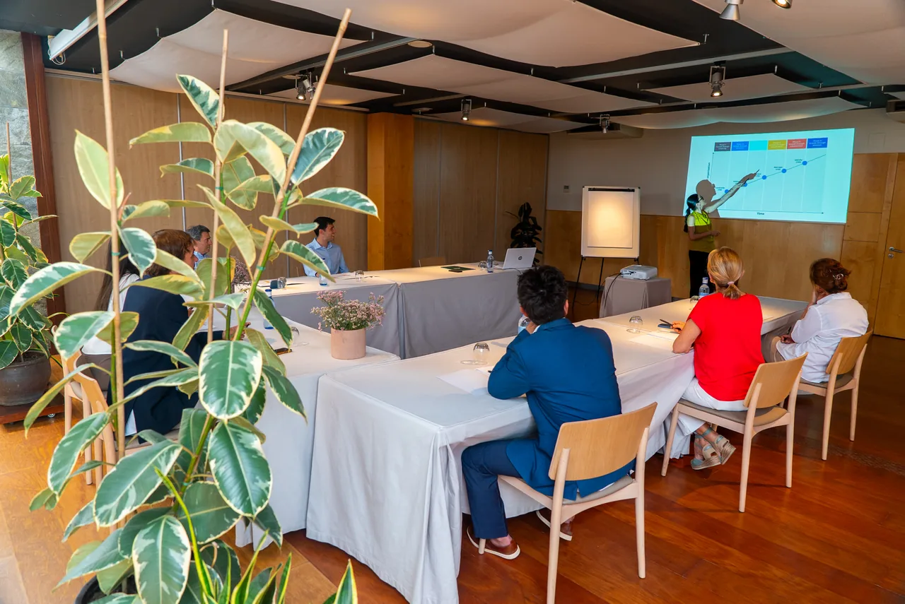 Sesión de trabajo en la sala del hotel, rodeada de plantas y luz natural